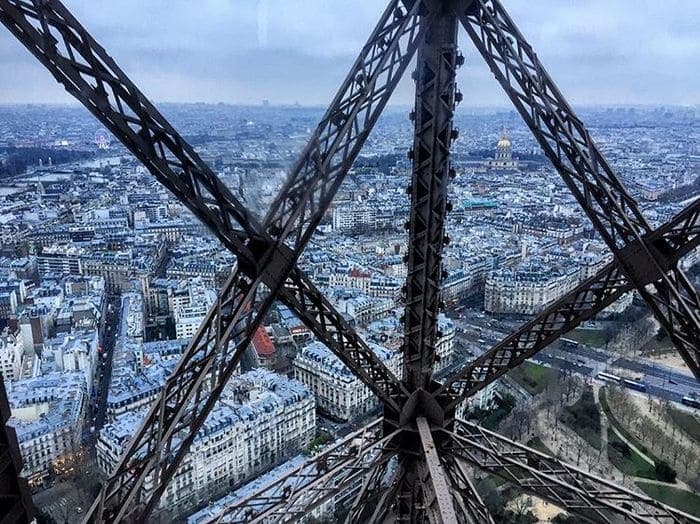 Vue de Paris à travers la structure de la Tour Eiffel